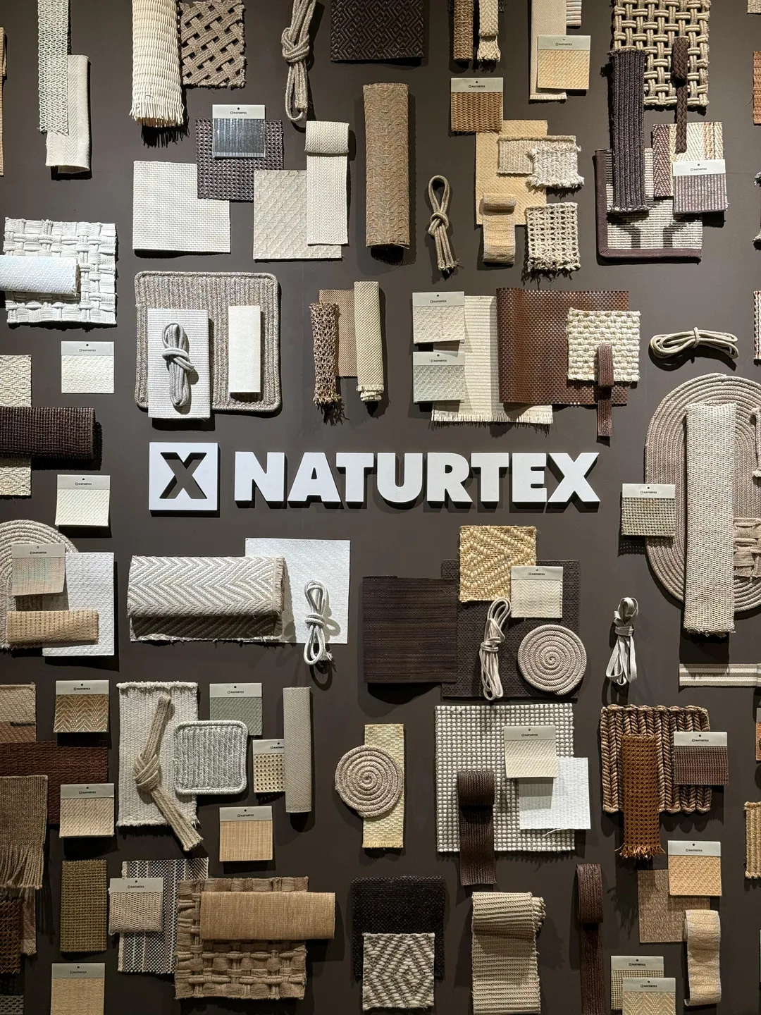 Painel de amostras de tecidos e fibras naturais da Naturtex no Salone del Mobile 2026